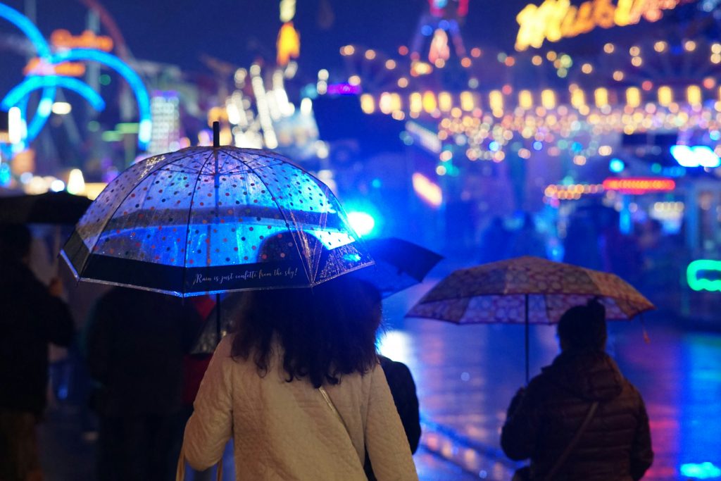 München bei Regen – Menschen mit Regenschirmen in der beleuchteten Stadt